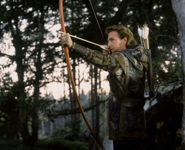 Kevin Costner als Robin Hood zielt mit gespanntem Bogen