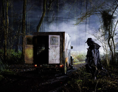 Der Creeper geht im Dunkeln auf seinen Truck zu. Die Türen des Laderaums sind offen.