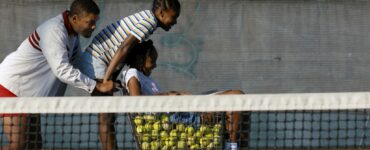 Will Smith schiebt als Richard Williams einen Einkaufswagen mit Tennisbällen. Auf diesem sind auch die Töchter Venus und Serena.