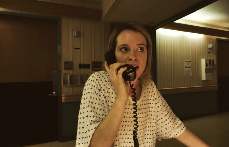 Claire Foy als Sawyer Valentini in Krankenhauskleidung am Telefon