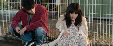 Leo und Monica hocken vor einem Gitterzaun erschöpft am Boden in First Love