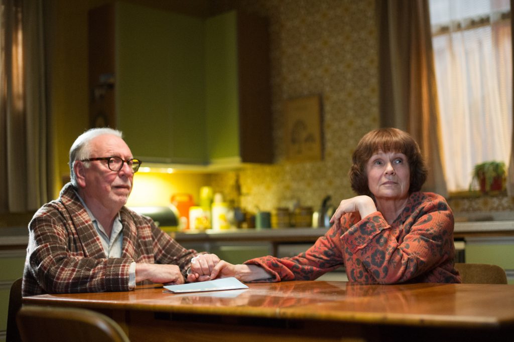 Kenneth Cranham und Julie Walters sitzen morgens am Küchentisch und schauen entgeistert drein in Film Stars Don't Die in Liverpool