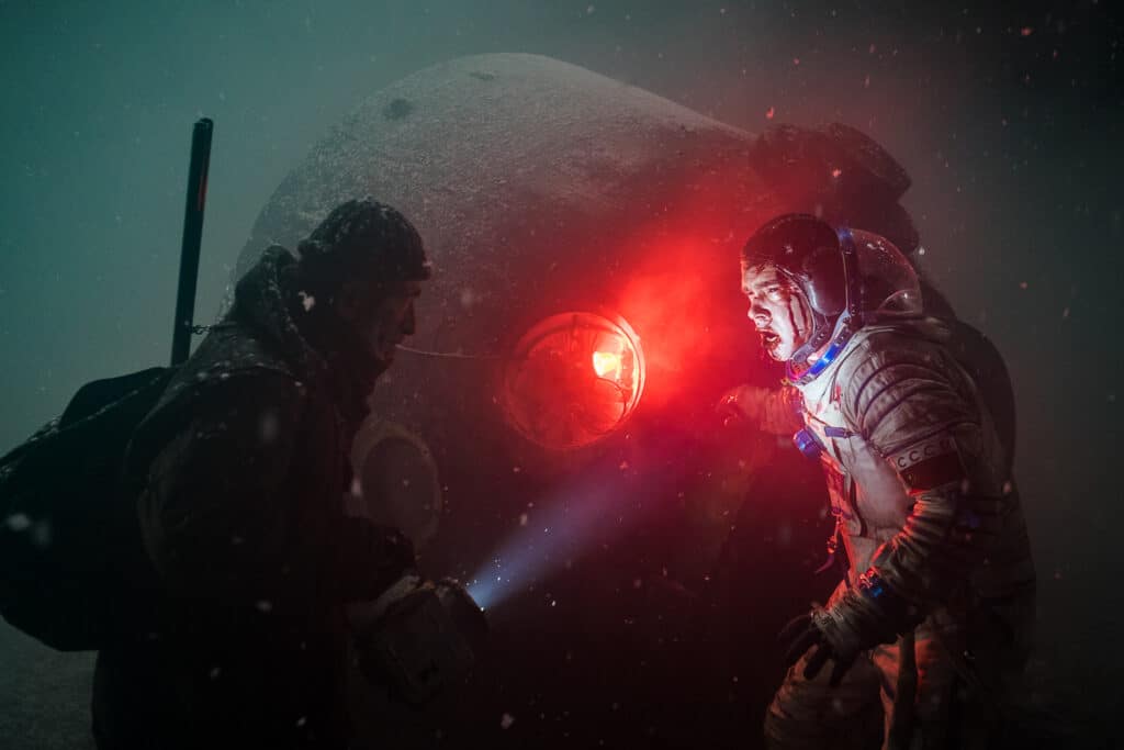 Ein Mann findet in Sputnik mit einer Taschenlampe die Raumkapsel und den verletzten Astronauten