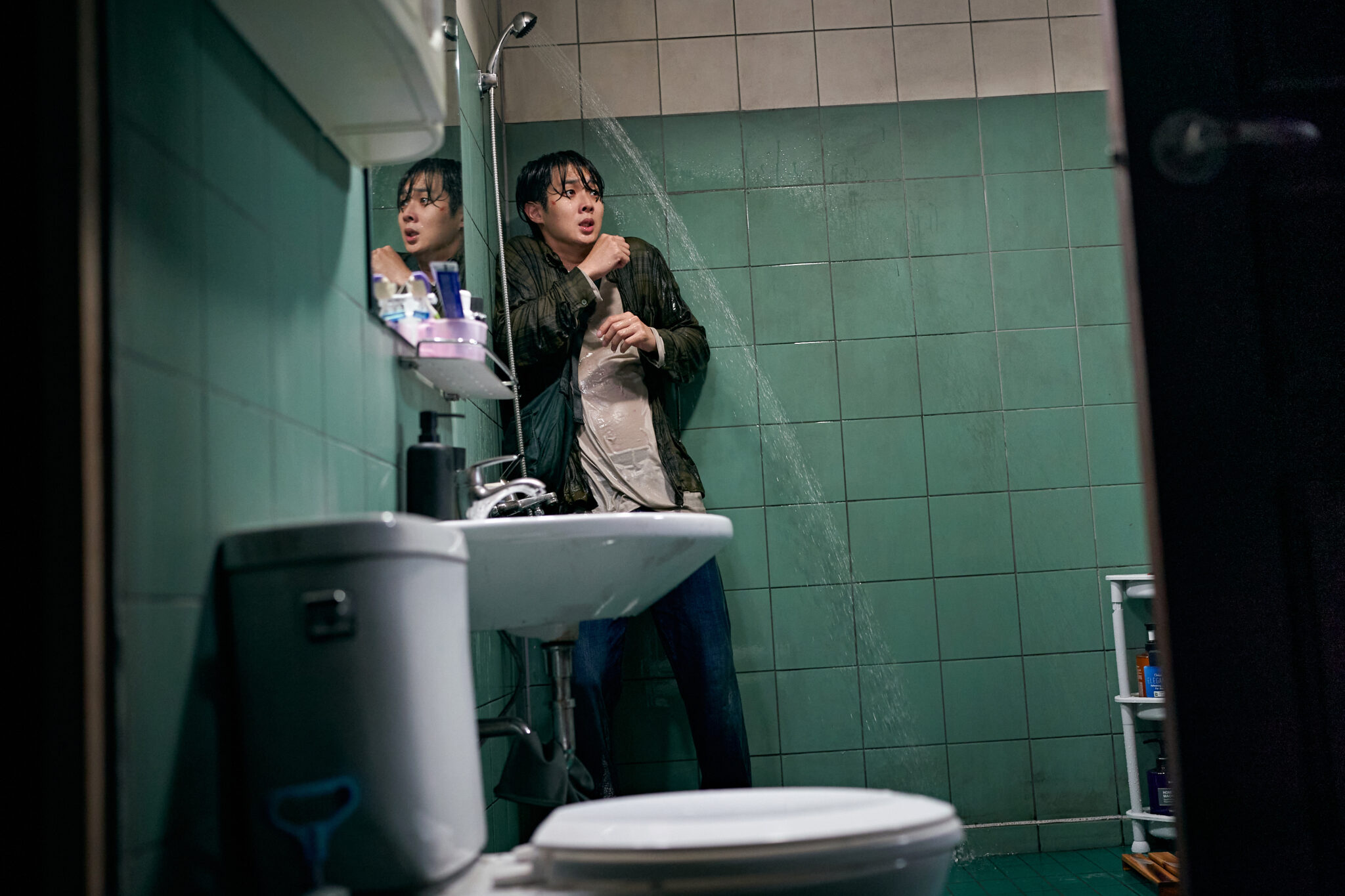 Choi Woo-shik in einem Bad in der Ecke angsterfüllt
