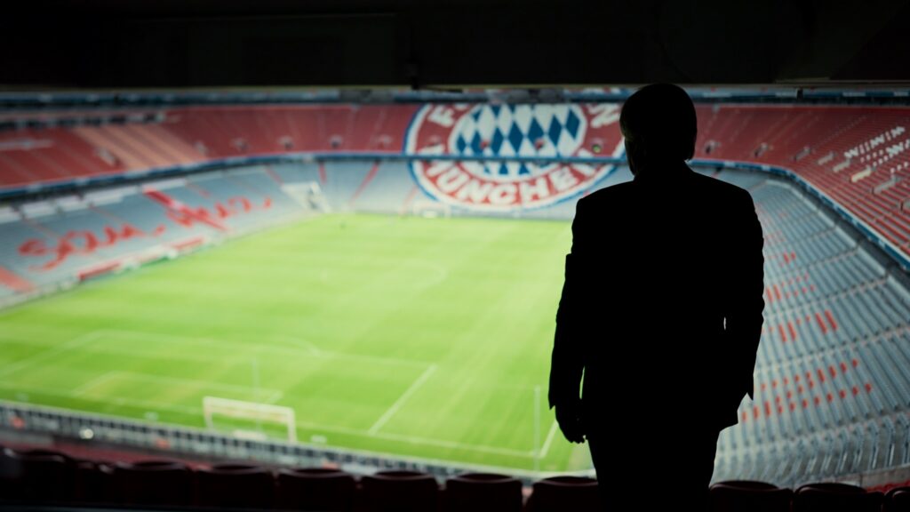 Ein Mann steht weit oben in der Allianz Arena und schaut auf das Spielfeld hinab - Neu bei Prime im November 2021