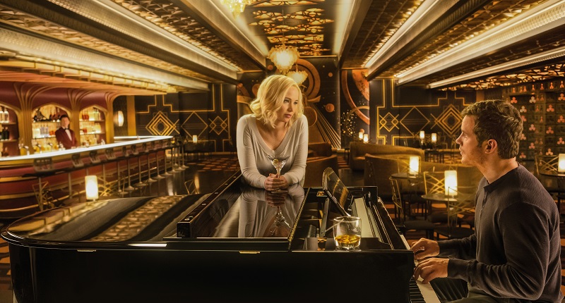 Chris Pratt sitzt im großen, gülden glänzenden Salon des Raumschiffs am Klavier, um Jennifer Lawrence zu beeindrucken in Passengers - Neu bei Prime im April 2020