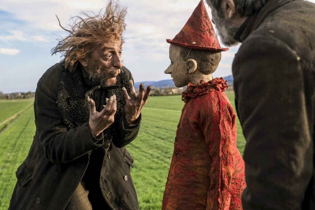 Ein zerzauster Mann mit schmutziger Kleidung und abstehendem Haar redet wild gestikulierend mit dem ruhigen Pinocchio - Neu bei Prime im Dezember 2020