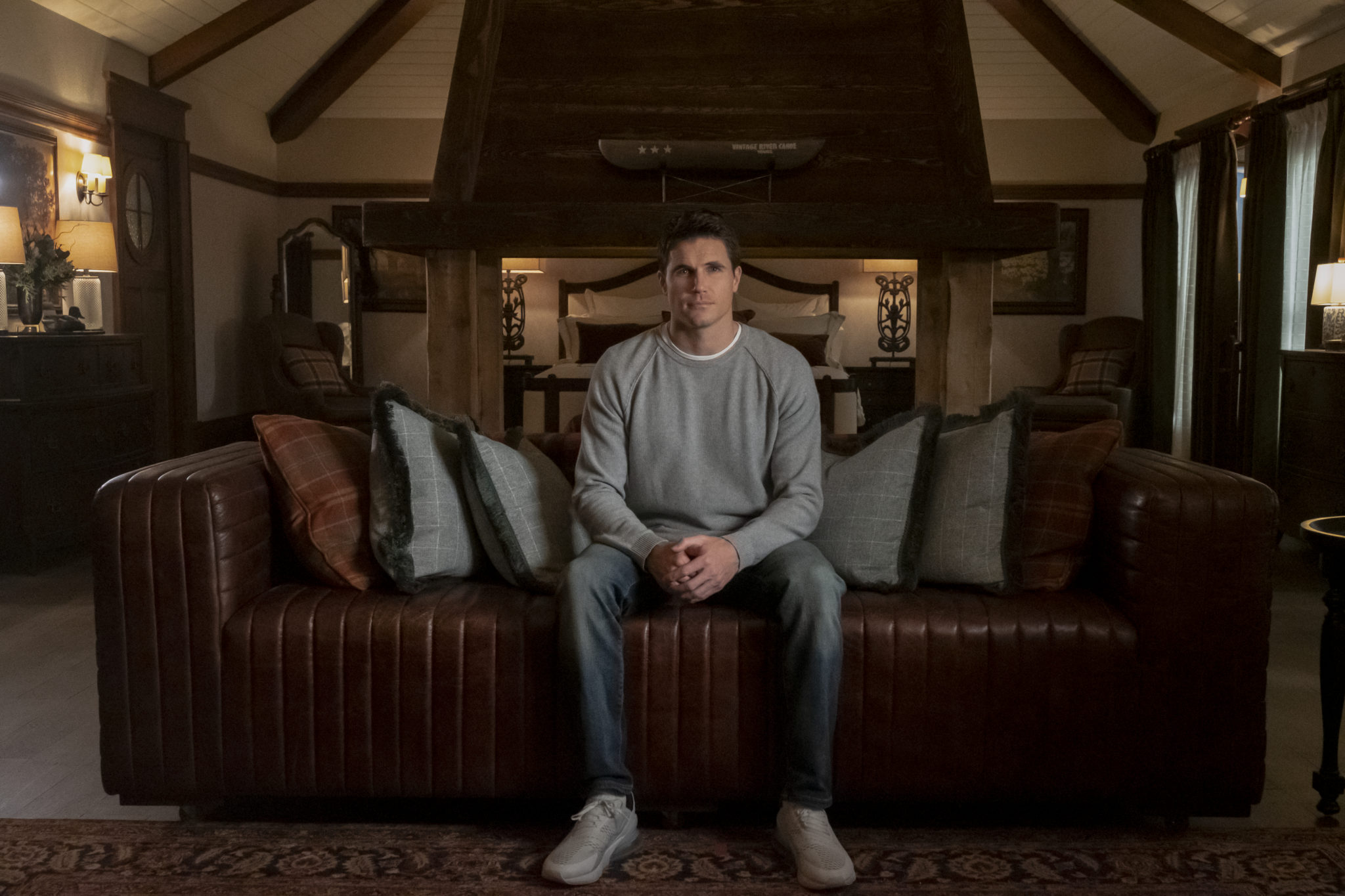 Nathan sitzt nachdenklich auf seiner Couch in seinem schönen, neuen Heim im Lake View Resort in Upload