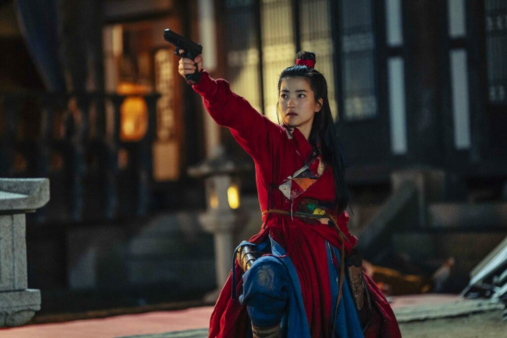 Kim Tae-ri als Lee Ahn steht mit gezogener Waffe und traditionellen Kleidern auf einem Hof in Südkorea | Alienoid