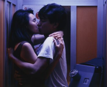 Maggie Cheung und Andy Lau küssen sich leidenschaftlich in einer Telefonzelle - As Tears Go By.