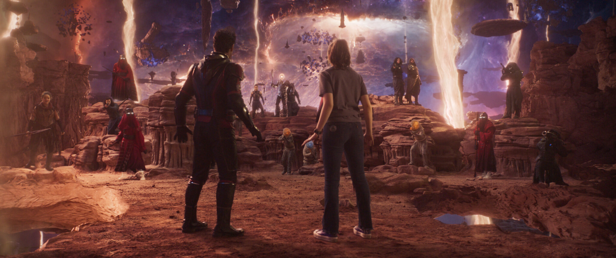 Paul Rudd Paul Rudd als Scott Lang/Ant-Man und Kathryn Newton als Cassandra "Cassie" Lang stehen auf einer wüstengleichen Planetenoberfläche während im Hintergrund viele Personen stehen und augenscheinlich warten.