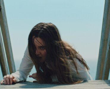 Emily (Liana Liberato) kämpft sich kriechend vom Strand zurück ins Haus. in The Beach House
