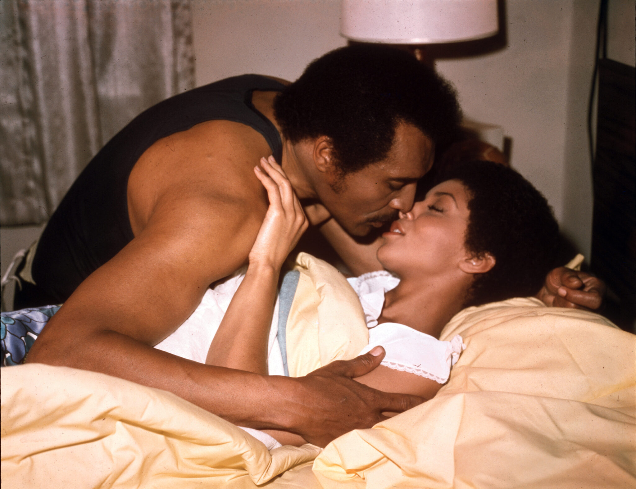 Mamuwalde "Blacula" (William Marshall) und Tina (Vonetta McGee) liegen gemeinsam in einem Bett, halten sich zärtlich in den Armen und deuten einen Kuss an.
