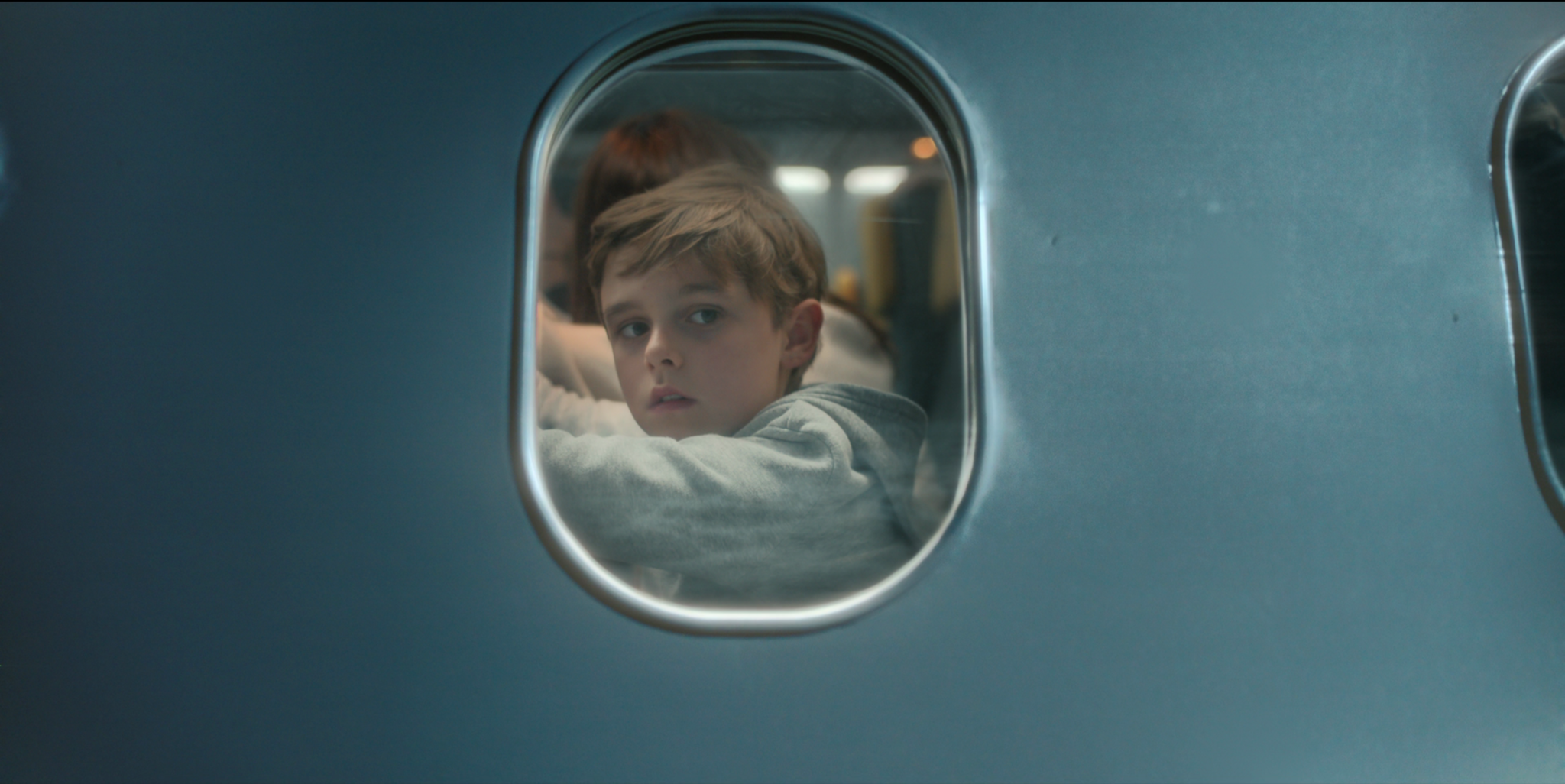 Carl Anton Koch als Sohn Elias in Blood Red Sky schaut aus einem Flugzeugfenster nach draußen.