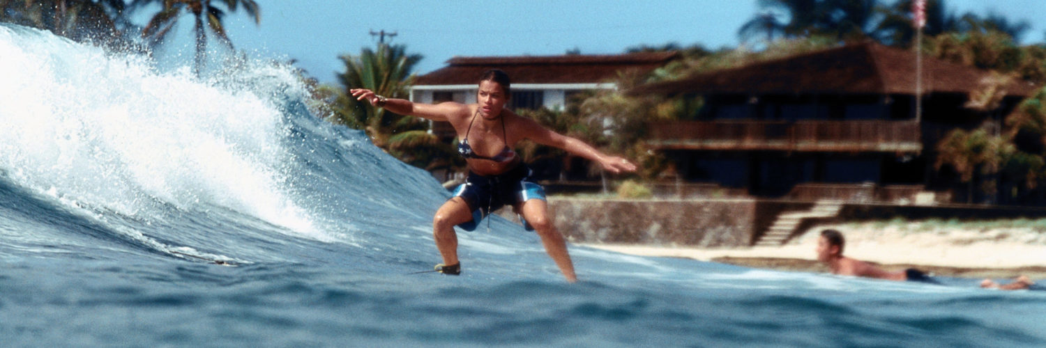 Michelle Rodríguez als Eden surft in "Blue Crush" mir unsicherem Blick auf einer Welle.