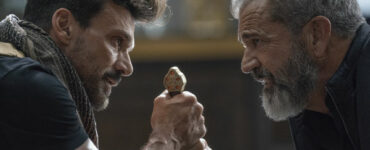 Frank Grillo und Mel Gibson stehen sich gegenüber und schauen sich in die Augen. Grillo hält dabei in beiden Händen einen Griff, der zu einem Schwert zu gehören scheint. - Boss Level