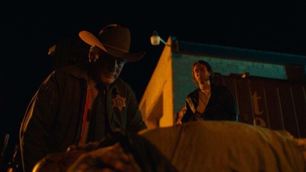 Sheriff Rex kniet im nächtlichen Candy Land über einer Leiche, hinter ihm steht der entsetzte Levi