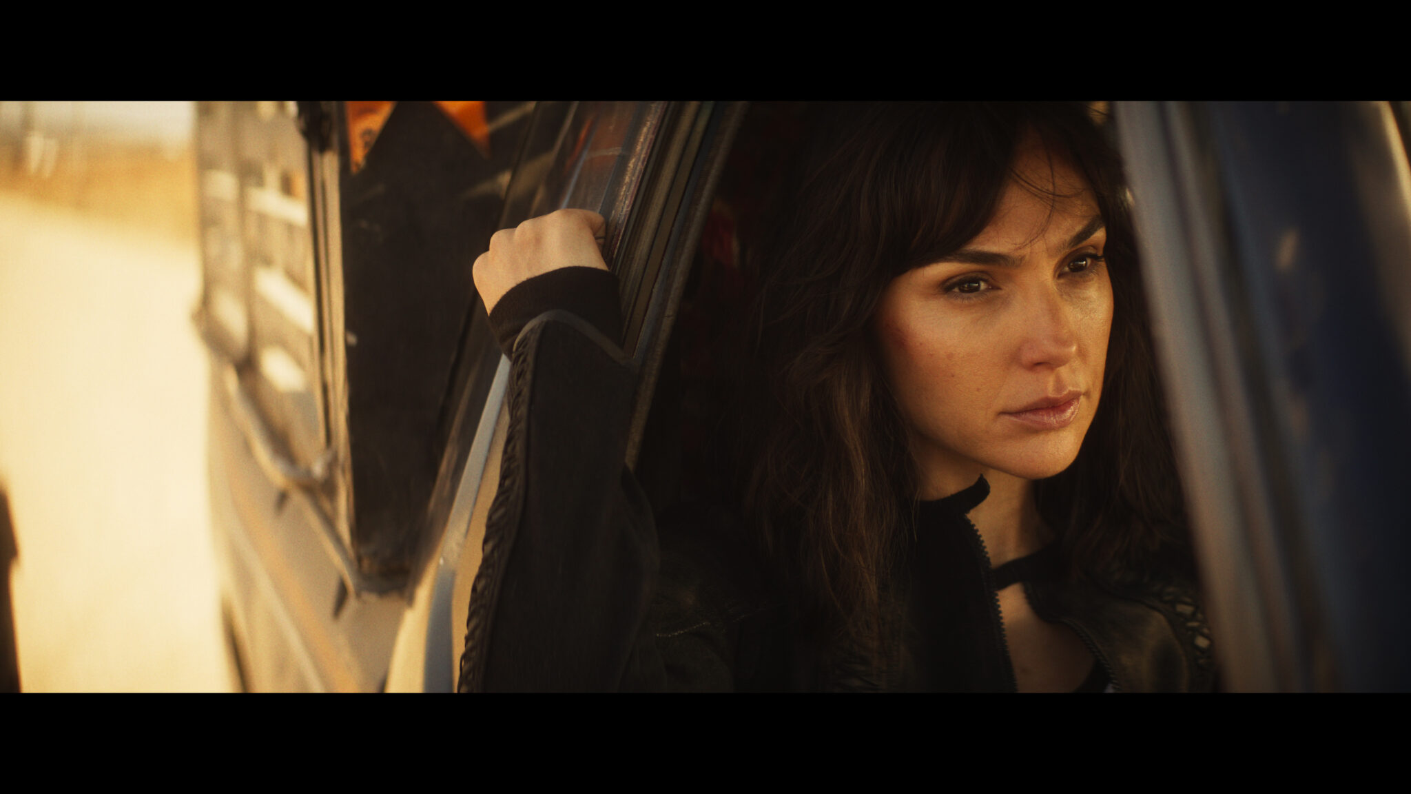 Gal Gadot als Rachel Stone in Heart of Stone. Sie sitzt in einem Wagen und schaut durchs offene Beifahrerfenster.