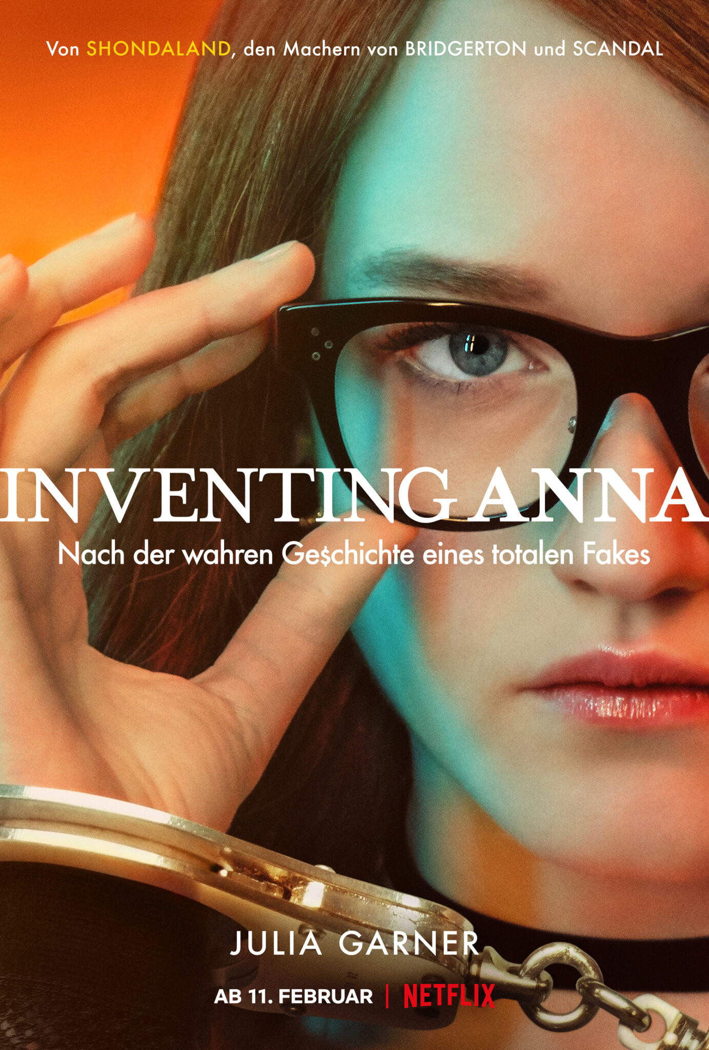 Das Poster zu Inventing Anna zeigt die Hauptfigur von nahem. Sie trägt eine Brille und hält diese mit ihren Fingern fest.