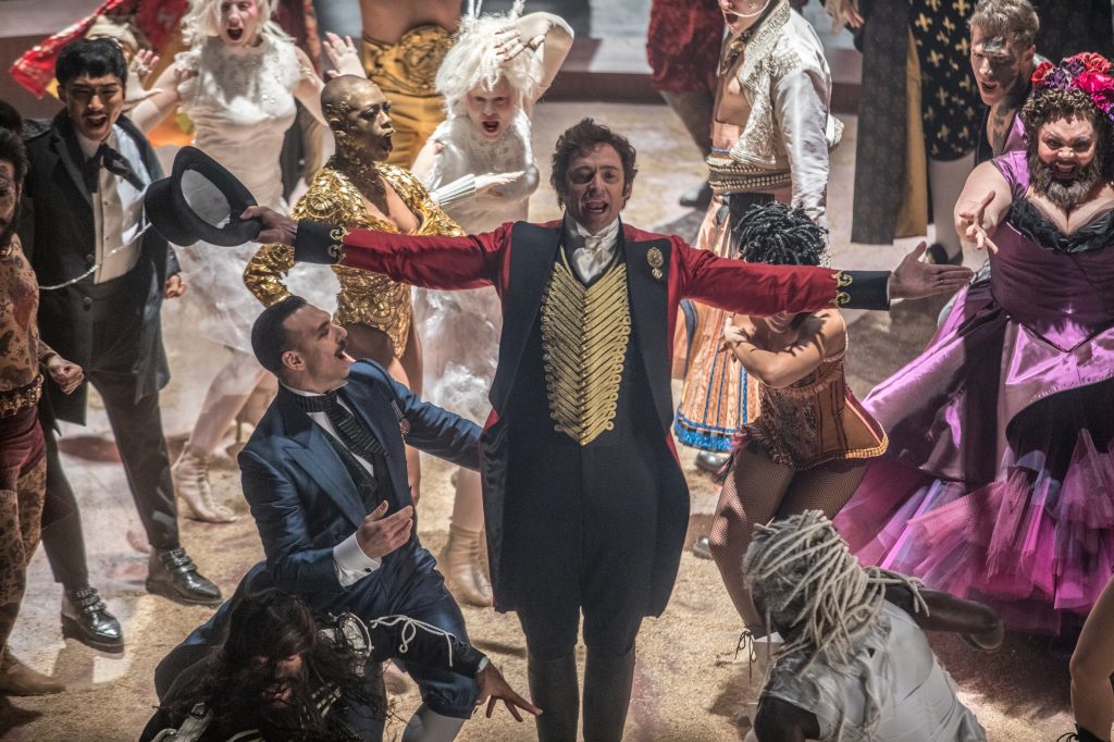 Hugh Jackman als "P. T. Barnum" inmitten seines farbenprächtig köstümierten Ensembles - Neu auf Netflix im November 2020