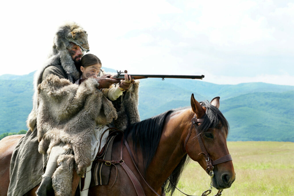 Der indianisch gekleidete Django, gespielt von Matthias Schoenaerts, geht mit seiner kleinen Tochter auf Büffeljagd. 
