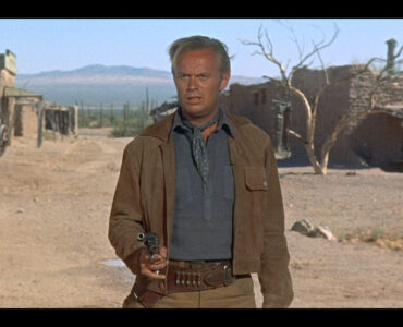 Jim Slater, gespielt von Richard Widmark, tritt in Das Geheimnis der fünf Gräber mit gezücktem Revolver zum finalen Duell an.