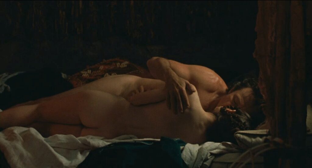 Auf einem zerwühlten Bett liegen Holly Hunter als Ada und Harvey Keitel in seiner Rolle als Baines. Beide sind völlig nackt, dabei liegt sie mit dem Rücken zu uns. Sie küssen sich und seine Hand liegt auf ihrer Schulter.