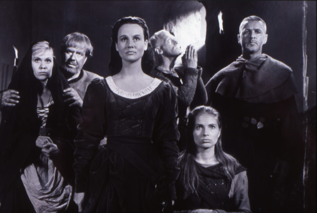 Max von Sydow als Block betet im Hintergrund, vor ihm stehen Jöns, das von dem Knappen gerettet Mädchen, Blocks Frau sowie der Schmied mit seiner Frau und starren nach vorne.