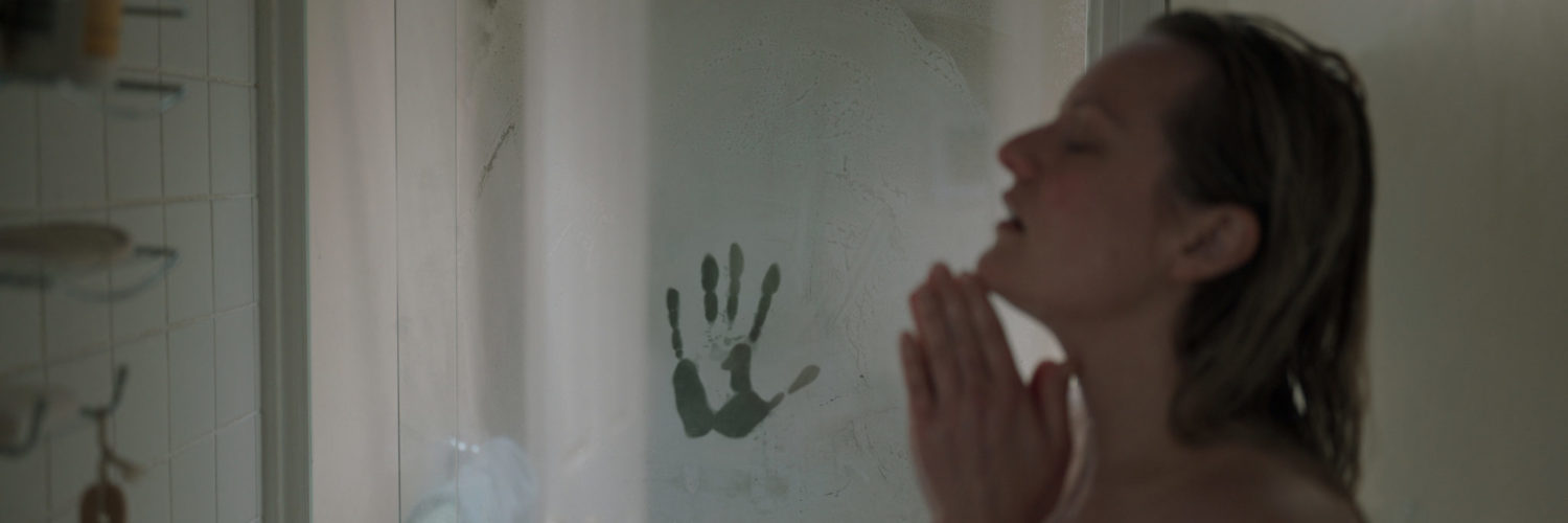 Protagonistin Cecilia (Elisabeth Moss) genehmigt sich eine warme Dusche, ihre Augen sind dabei geschlossen. Neben ihr ist ein Handabdruck an der beschlagenen Duschkabine zu sehen - der Unsichtbare beobachtet sie.