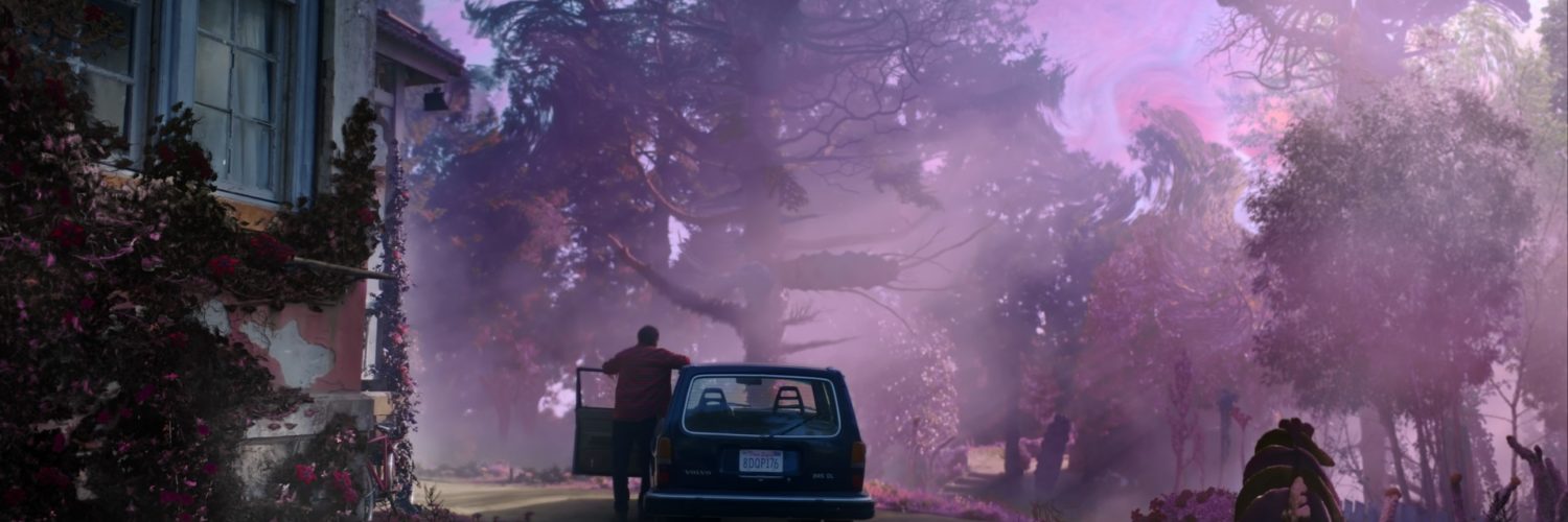 Nicolas Cage als Nathan Gardner steigt, in einer Totalen von hinten gesehen, aus seinem Auto und erblickt sein violett leuchtendes Land in DIE FARBE AUS DEM ALL.