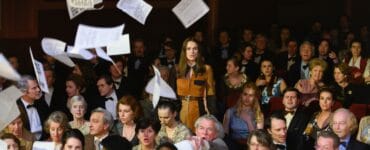 Sally Alexander, gespielt von Keira Knightley, steht im Publikum der Miss-Wahl auf und wirbelt Flugblätter über die Menge.