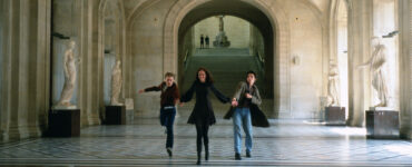 Isabelle (Eva Green), Matthew (Michael Pitt) und Theo (Louis Garrel) sprinten in Die Träumer Hand in Hand durch das Louvre, um den Geschwindigkeitsrekord aus Jean-Luc Godards Die Außenseiterbande zu knacken.