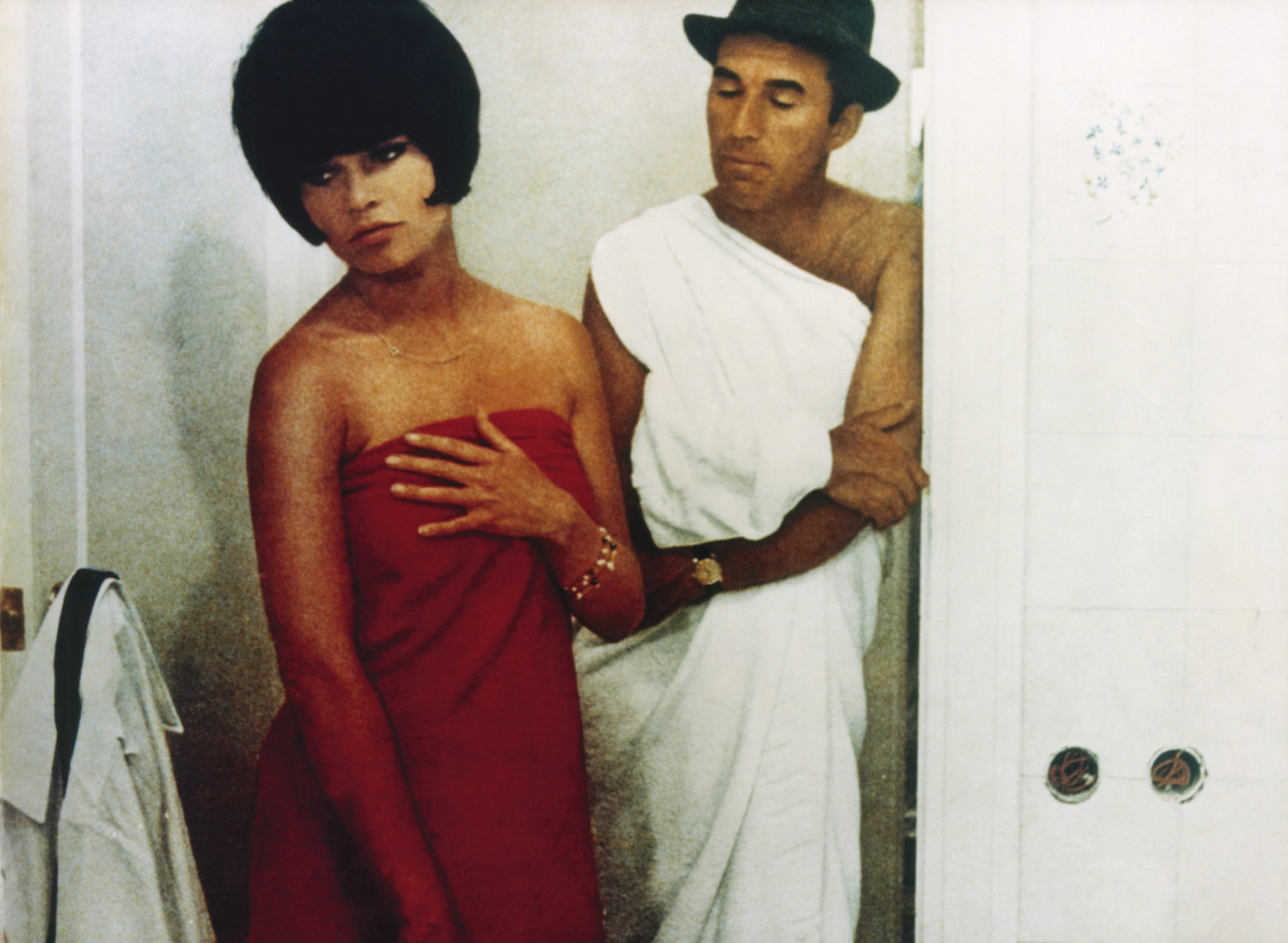 Paul (Michel Piccoli) und Camille (Brigitte Bardot) stehen in ihrer Wohnung. Camille ist umhüllt von einem roten Handtuch, Paul von einem weißen. Camilles Blick unterstreicht ihr Gefühl: Verachtung.