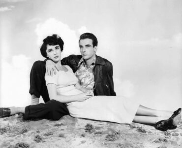 George Eastman (Montgomery Clift) und Angela Vickers liegen in Ein Platz an der Sonne aneinander gelehnt auf dem Boden und schauen in die Ferne.