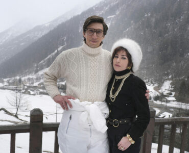 Adam Driver und Lady Gaga posieren als das Ehepaar Gucci auf einer Terasse vor den verschneiten Bergen - House of Gucci