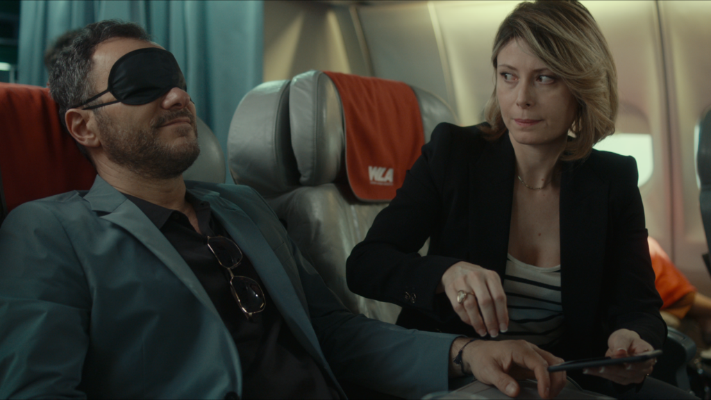 Eine Frau klaut ihrem schlafenden Sitznachbarn im Flugzeug vorsichtig das Handy - Neu auf Netflix im Juli 2020