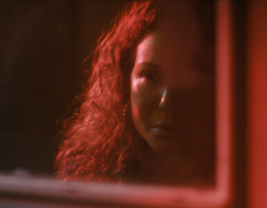 Auf dem Bild erkennt man Dolores im roten Licht, wie sie sich im melancholisch im Spiegel anschaut