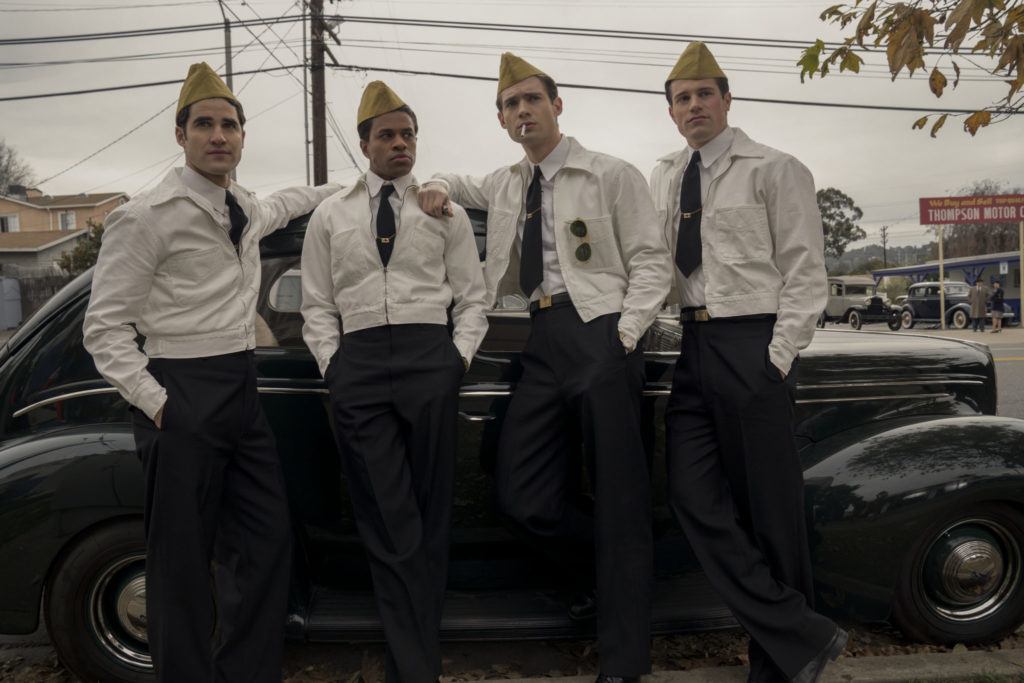 Die vier Crew-Mitglieder des Films treffen sich vor einem Auto an der Tankstelle