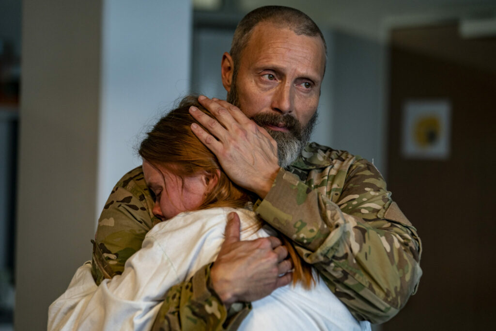 Soldat Markus (Mads Mikkelsen) umarmt seine Tochter Mathilde (Andrea Heick Gadeberg). Sein Blick wirkt gefasst, aber seine Augen zeigen die Trauer um den Verlust in ihrer Familie. - "Helden der Wahrscheinlichkeit"