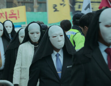 Fanatiker mit weißen Masken marschieren in Hellbound durch die Straßen