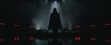 Der ikonische Star-Wars-Antagonist Darth Vader in einem dunklen Raum mit einzelnen roten Lichtern.