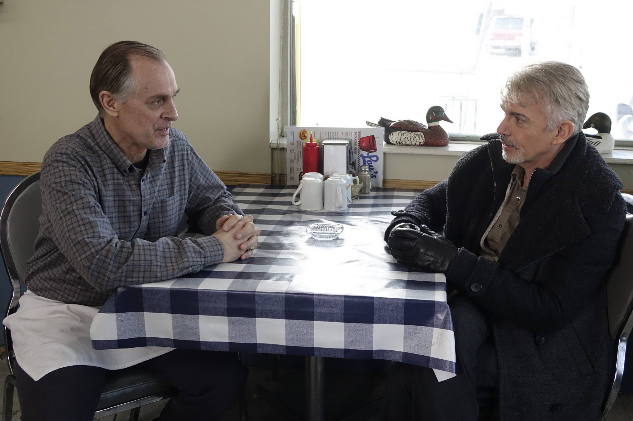 Keith Carradine und Billy Bob Thornton sitzen sich gegenüber in der ersten Staffel Fargo