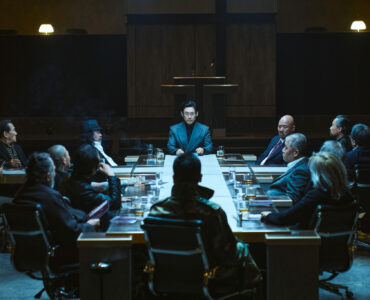 ein kreuzförmiger Tisch mit Männern in Anzügen.