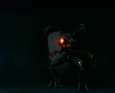 Das Bild aus der Serie Lost in Space zeigt zwei Kinder und einen furchteinflößenden Roboter in der Dunkelheit