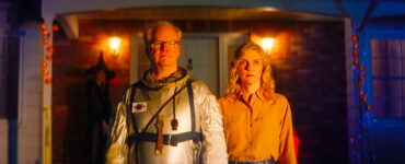 Jim Gaffigan trägt einen Astronautenanzug und steht neben Rhea Seehorn