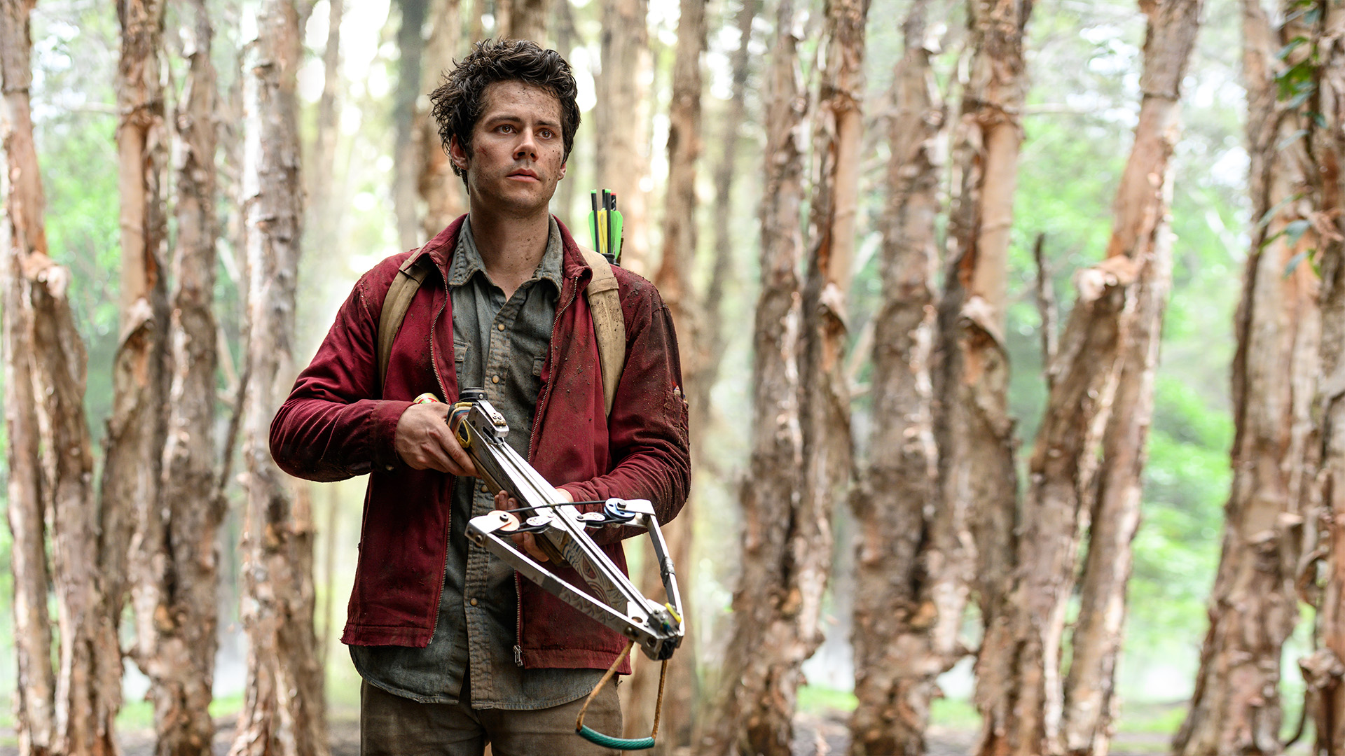 Dylan O'Brien in Love and Monsters mit einer Armbrust im Wald