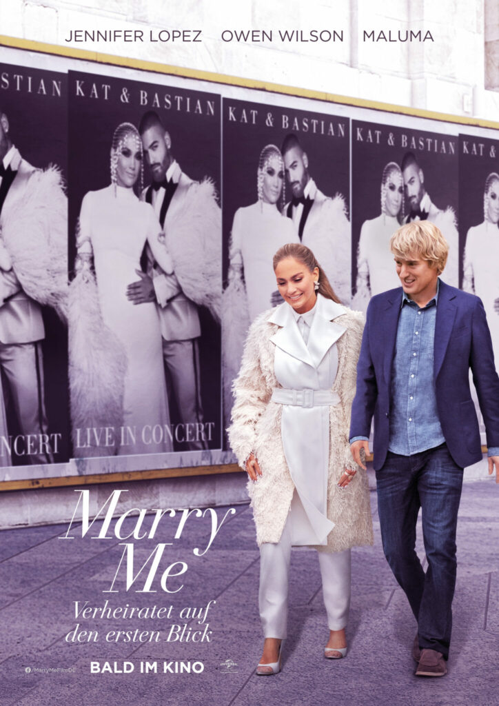 Kat Valdez und Charlie gehen Hand in Hand an Plakaten zu Marry Me von ihr und Bastian vorbei