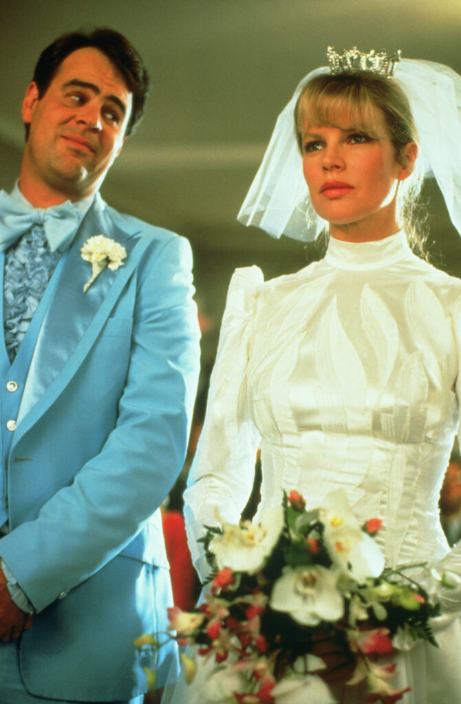 Auf dem Bild sind Steve (Dan Aykroyd) und Celeste (Kim Basinger) bei ihrer Hochzeit zu sehen. Die Braut steht klassisch weiß mit Schleier und der verliebt dreinblickende Bräutigam einen hellblauen Frack - "Meine Stiefmutter ist ein Alien"
