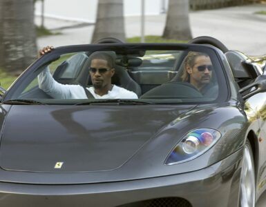 Zwei Männer mit Sonnenbrillen in einem Sportwagen ohne Dach