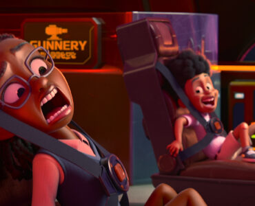 Zwei Kinder in einer Animationsserie in einem Fahrerraum jeweils angeschnallt auf ihren Sitzen mit panischen Ausdrücken